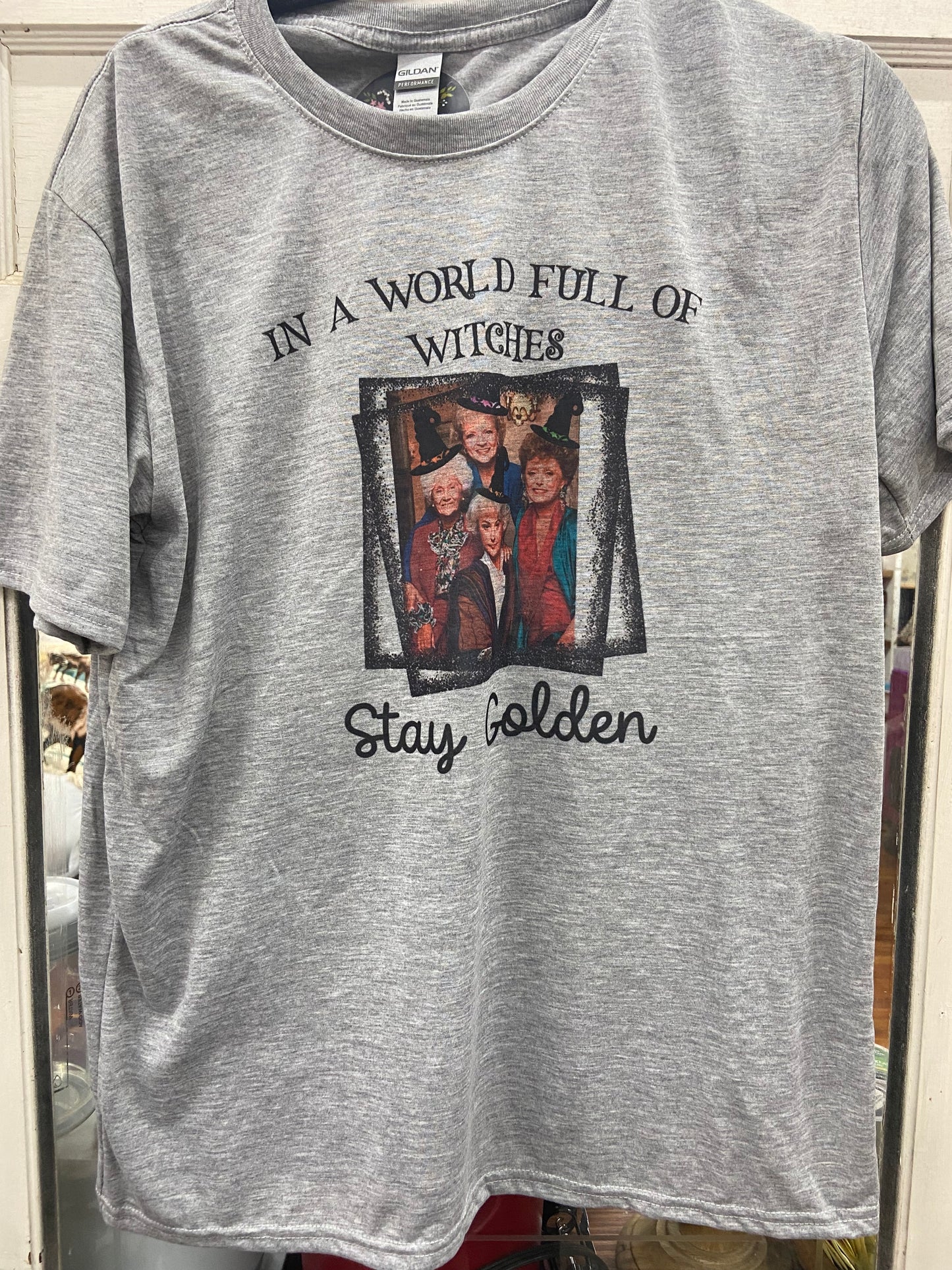 “In a world full of witches stay golden” tee