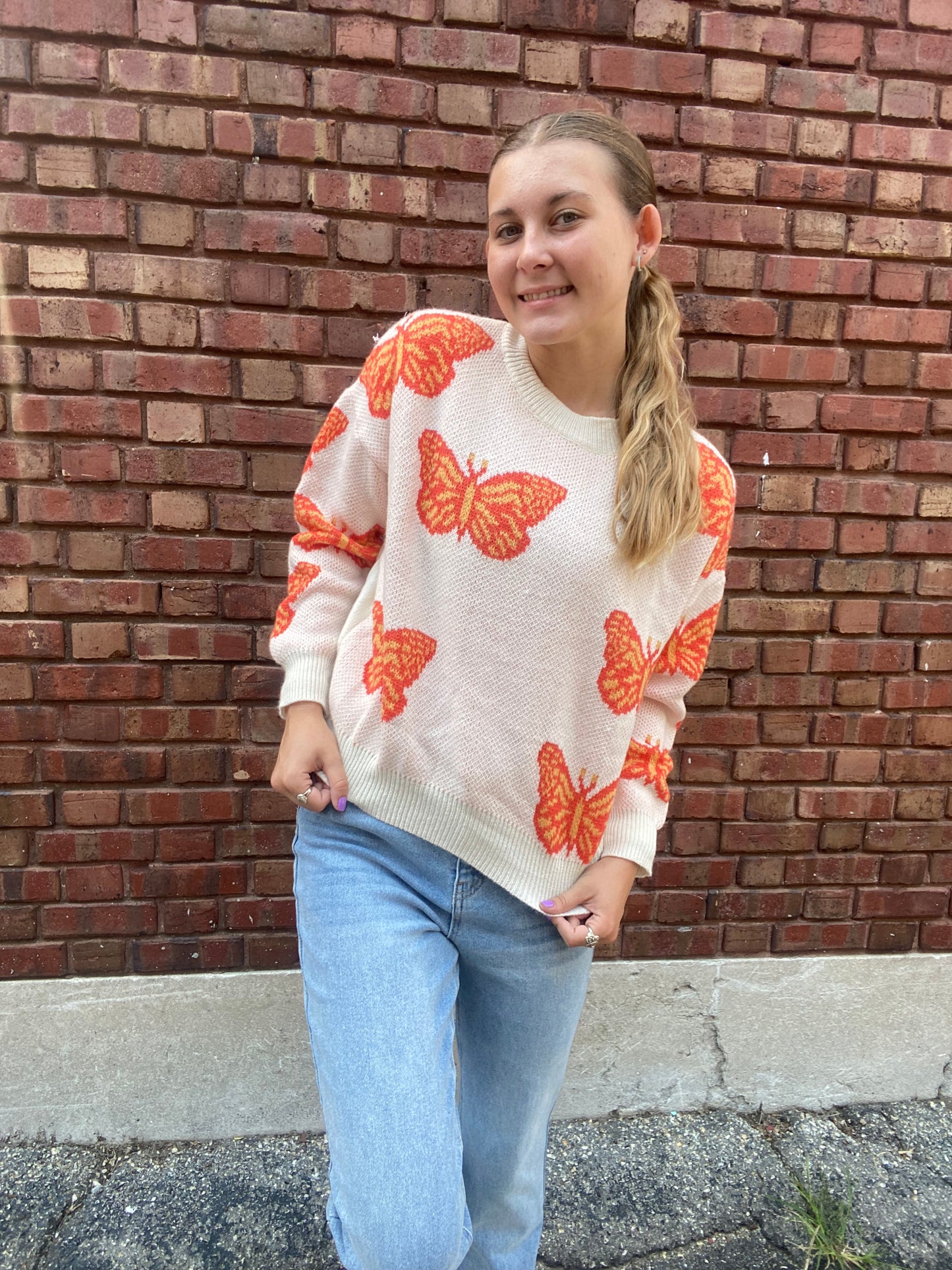 Pink sweater with orange butterfly